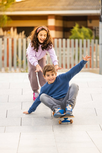 Two friends playing with a skate board - Zdjęcie, obraz