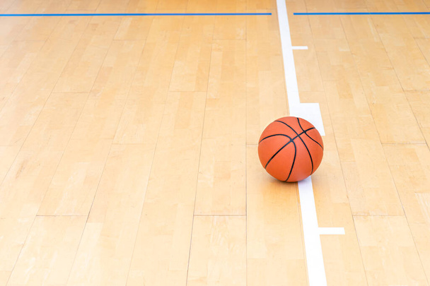 Basketball auf Hartholzfußboden mit natürlichem Licht. Workout Online-Konzept. Horizontales Sport-Themenposter, Grußkarten, Kopfzeilen, Website und App - Foto, Bild