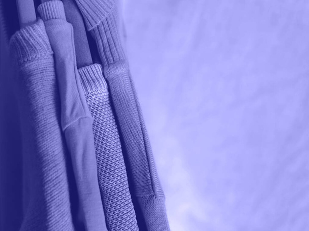 Purple very peri color winter sweaters on hangers - Photo, Image