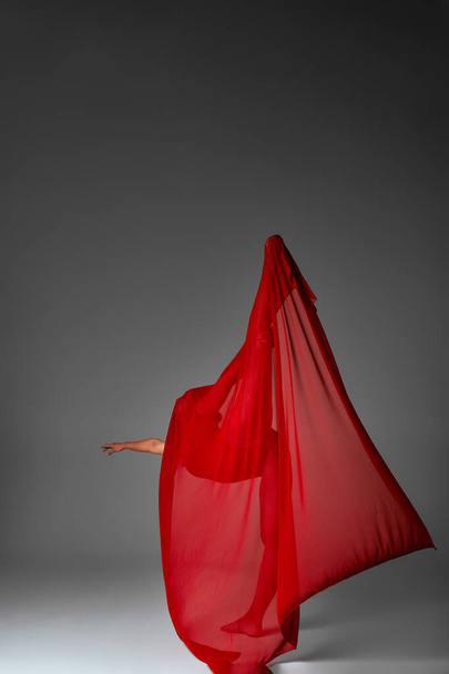 Bailarina saltando en zapatos de punta con paño rojo volador, danza moderna del ballet, fondo gris aislado - Foto, imagen