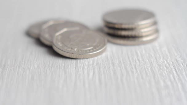 Украинская монета в пять гривен разворачивается на стопку других монет крупным планом - Кадры, видео
