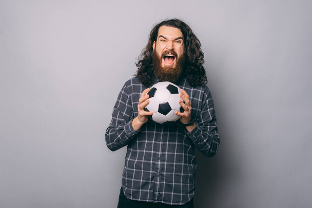 Izgatott férfi focival a stúdióban - Fotó, kép