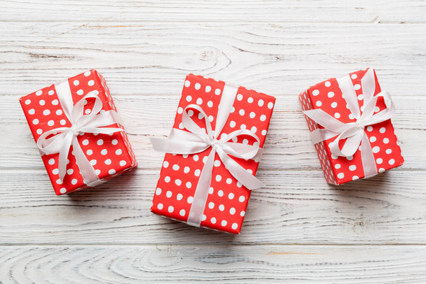Σύνθεση του Αγίου Βαλεντίνου Ιστορικό: κόκκινο κουτί δώρου με φιόγκο και καρδιά. Χριστουγεννιάτικο δώρο. Θέα από ψηλά. Holday ευχετήρια κάρτα. - Φωτογραφία, εικόνα