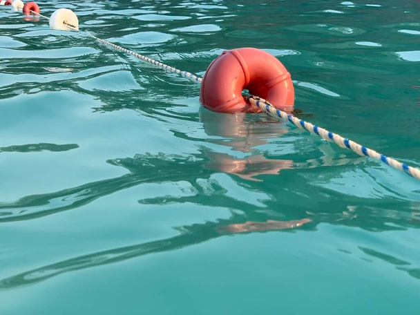 Rantapoijut köydessä meressä. Merkki uimisesta sinisessä vedessä. Uintiväylä altaassa. Konsepti: uinti lämpimässä meressä, vesiurheilu. - Valokuva, kuva