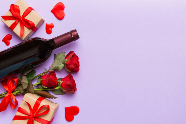 Walentynki kompozycja z czerwonym winem, kwiat róży i pudełko na stole. Widok z góry, płaski. Koncepcja wakacji. - Zdjęcie, obraz