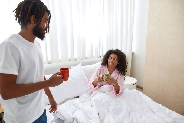 Black couple drinking tea at home at morning - 写真・画像