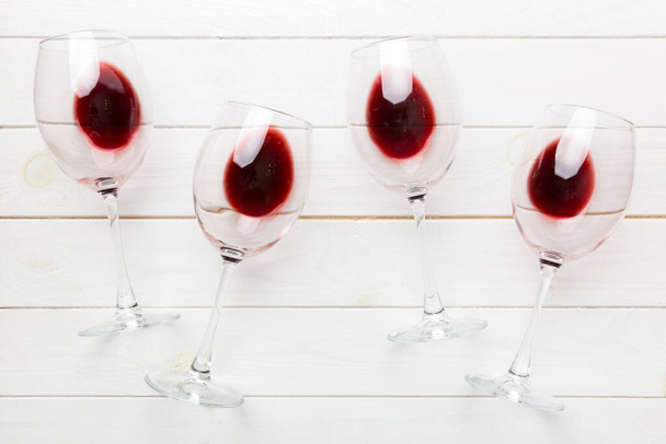 Wiele kieliszków czerwonego wina podczas degustacji wina. Pojęcie czerwonego wina na kolorowym tle. Widok z góry, płaski projekt układanki. - Zdjęcie, obraz