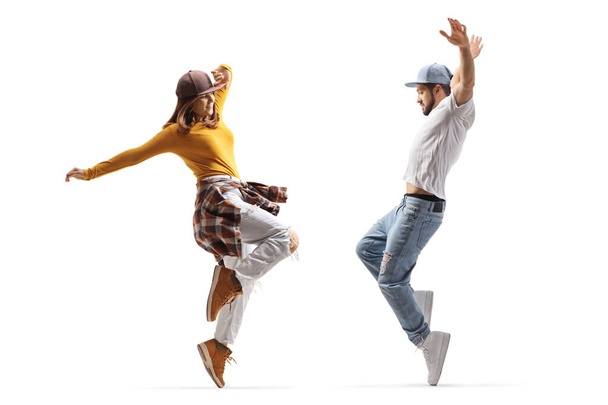 Full length profile shot of a guy and girl dancing hip hop isolated on white background - Fotografie, Obrázek