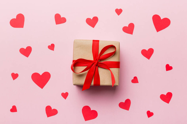 Composición San Valentín Fondo: caja de regalo roja con arco y corazón. Regalo de Navidad. Vista desde arriba. Tarjeta de felicitación Holday. - Foto, imagen