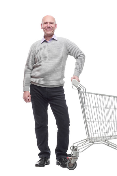 in full growth. a happy man with a shopping cart. - Φωτογραφία, εικόνα