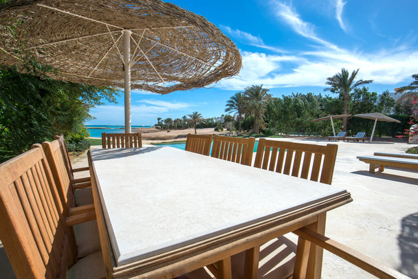 Ylellinen huvila näyttää kotiin trooppinen kesäloma keinona uima-allas ja ulkona ruokapöytä alue
 - Valokuva, kuva