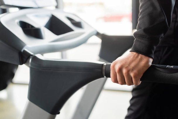 Cropped view of sportsman training on treadmill in gym  - Фото, изображение