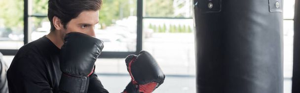スポーツマンボクシンググローブトレーニングでパンチングバッグでジム、バナー  - 写真・画像