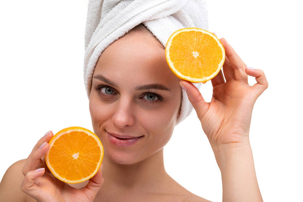 beautiful woman after shower with a cut orange in her hands skin care concept - Foto, imagen