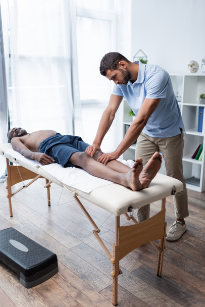 full length view of mature african american man lying on massage table during massotherapy  - Fotoğraf, Görsel