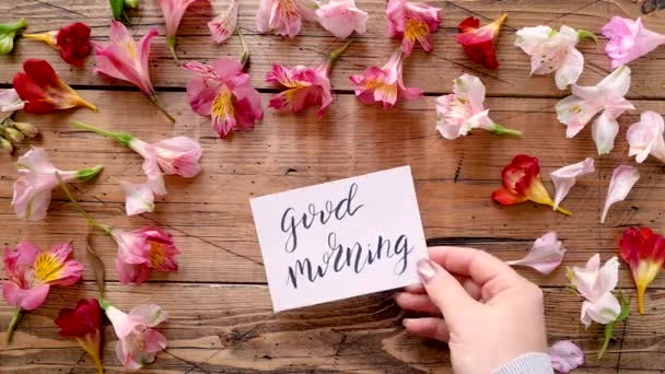 Zet een GOED MORNING kaart in de buurt van bloemen bovenaanzicht  - Video