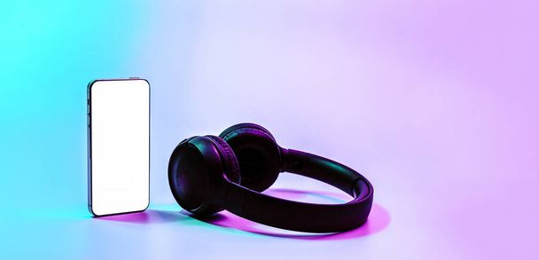 Smartphone screen. Mobile smart phone technology blank screen. Mock up smart phone device, audio headphones equipment on neon gradient background. For text message, information content, clipping path - Photo, image
