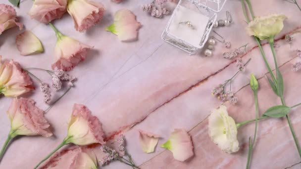 Main met la carte LOVE sur une table en marbre près de fleurs roses gros plan  - Séquence, vidéo
