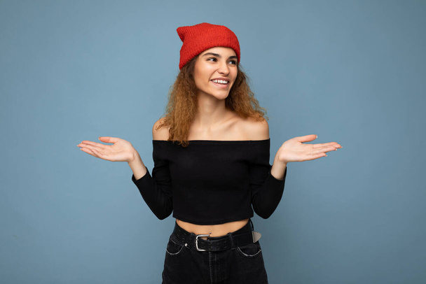Foto van jonge positieve vrolijke glimlachende mooie vrouw met oprechte emoties dragen stijlvolle kleren geïsoleerd over de achtergrond met kopieerruimte - Foto, afbeelding