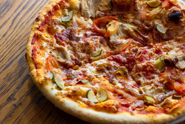 Свежая выпечка домашней нарезанной пиццы с сыром и ветчиной на деревянном фоне. - Фото, изображение