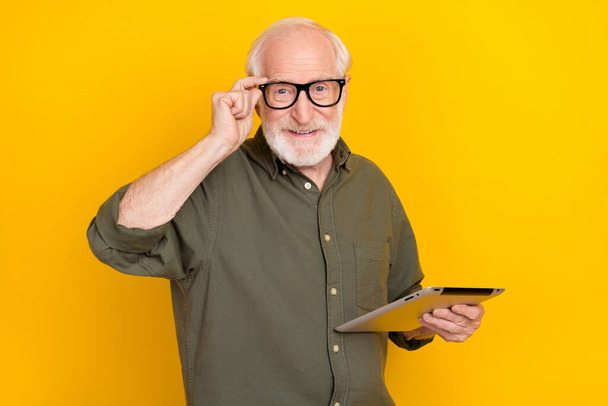 Portrait of candid friendly aged person hand touch eyewear look camera isolated on yellow color background - Fotografie, Obrázek
