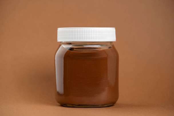 Шоколадно-кремова пляшка ізольована на коричневому фоні
 - Фото, зображення