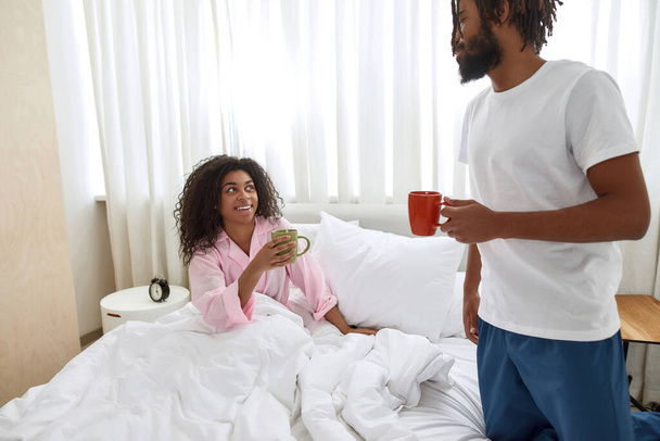 Black couple drinking tea or coffee in bedroom - Fotó, kép