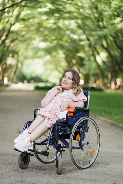 Woman with spinal muscular atrophy smiling at park - Foto, afbeelding