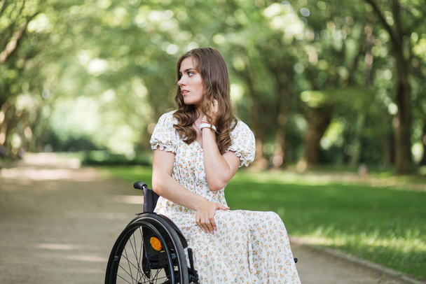 Attractive woman with disability looking around at park - Фото, изображение