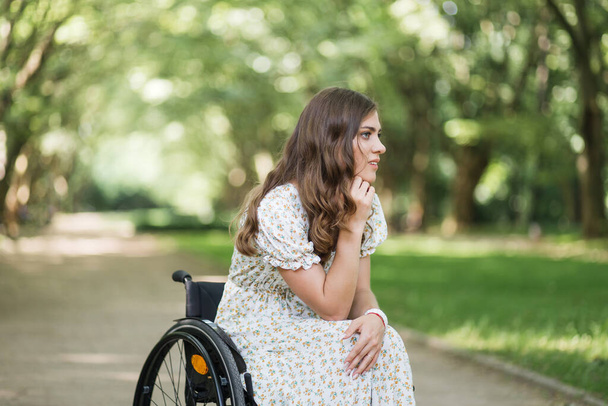 Attractive woman with disability looking around at park - Foto, afbeelding