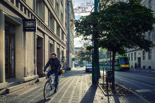 POZNAN - POLONIA - 2021: Gente, coches y tranvía en la calle de la mañana de la gran ciudad  - Foto, Imagen
