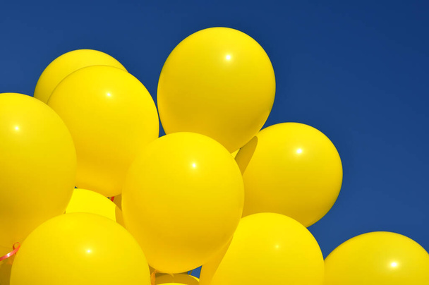  yellow balloons in the city festival against deep blue sky - 写真・画像