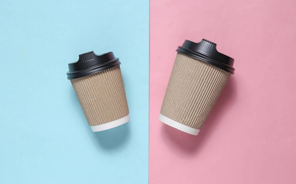 Due tazze di caffè in cartone su sfondo blu rosa pastello - Foto, immagini