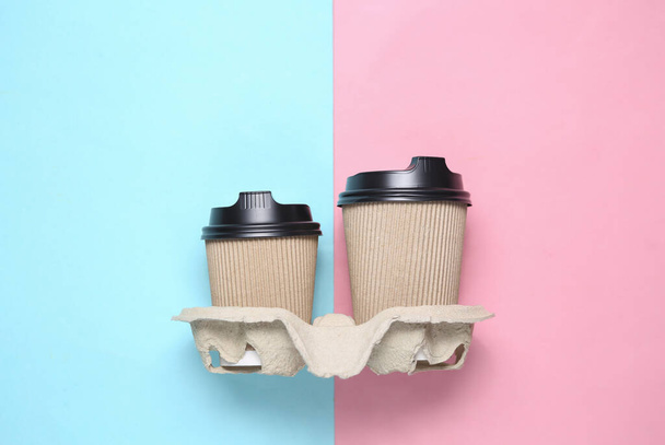 Δύο χάρτινα φλιτζάνια καφέ σε μπλε ροζ παστέλ φόντο - Φωτογραφία, εικόνα