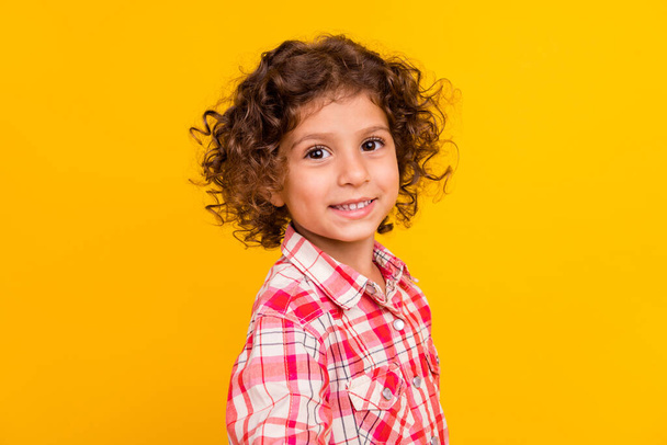 Photo of sweet charming school girl dressed checkered clothes smiling isolated yellow color background - Zdjęcie, obraz