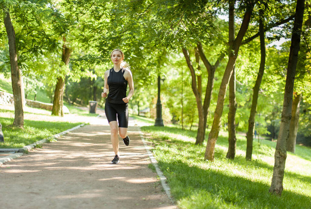 Jeune femme blonde jogging dans le parc - Photo, image