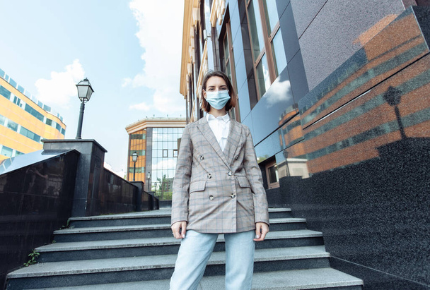 Портрет деловой женщины в медицинской маске в городе - Фото, изображение