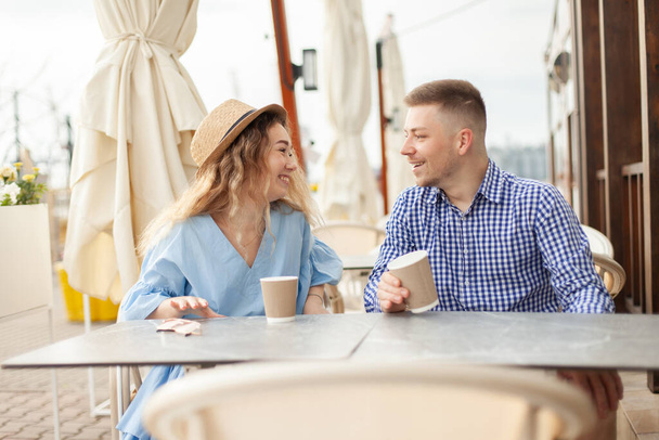 Νεαρό ερωτευμένο ζευγάρι περνάει χρόνο μαζί σε υπαίθριο καφέ. Αγάπη ρομαντική έννοια - Φωτογραφία, εικόνα