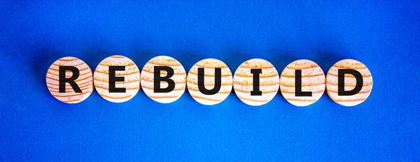 Rebuild and build symbol. The concept word Rebuild on wooden circles. Beautiful blue background, copy space. Business rebuild and build concept. - Fotografie, Obrázek