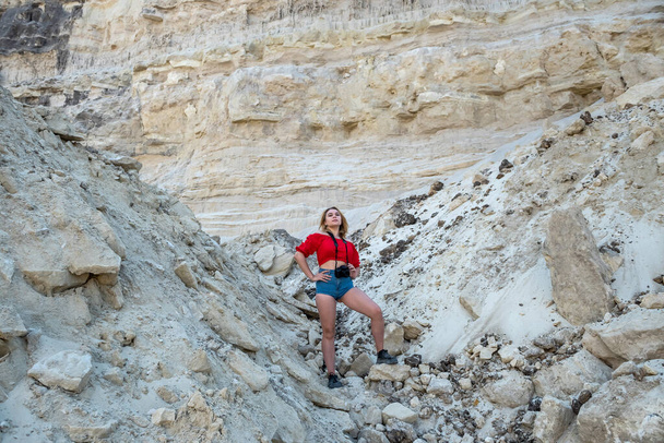 stijlvolle jonge vrouw reist door canyons en zand rotsen het nemen van foto 's en genieten van zomervakantie - Foto, afbeelding