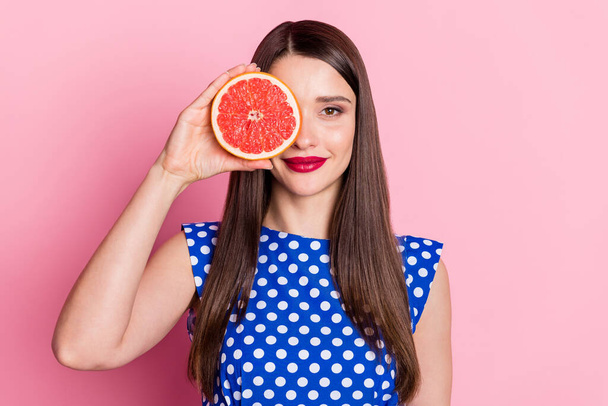 Photo of young attractive woman happy positive smile cover eye fruit grapefruit isolated over pastel color background - Foto, immagini