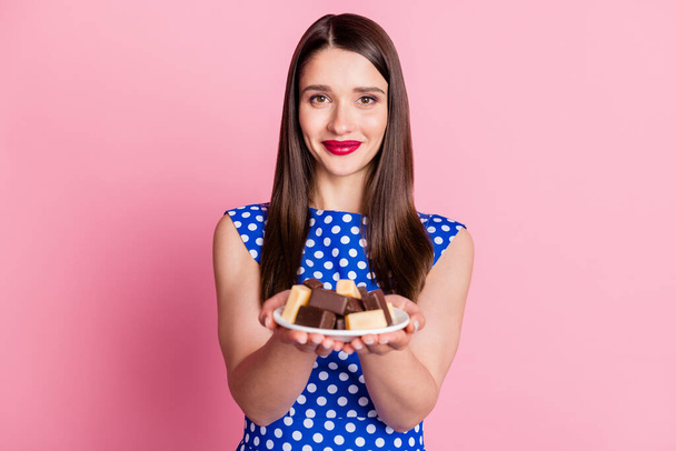 Photo of young attractive woman happy positive smile hold plate chocolate candy sugar diet isolated over pastel color background - Valokuva, kuva