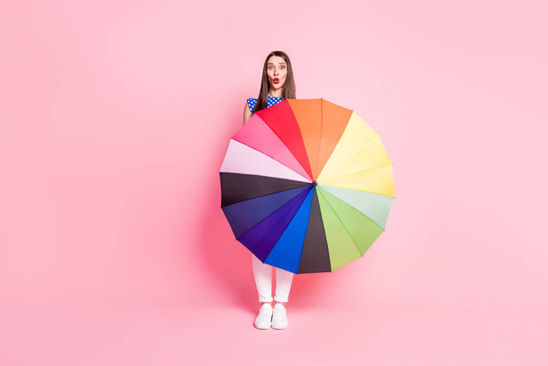 Фотографія повного розміру молодої привабливої жінки, розкидані губи, тримають парасольку ізольованою на пастельному кольоровому фоні
 - Фото, зображення