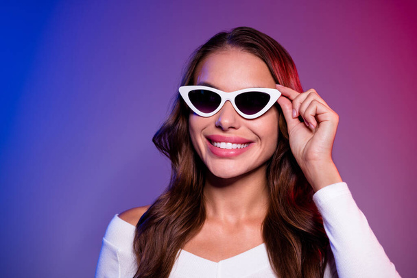 Photo of adorable pretty young lady dressed off-shoulders shirt arm dark eyewear smiling empty space isolated filter red blue color background - Foto, imagen