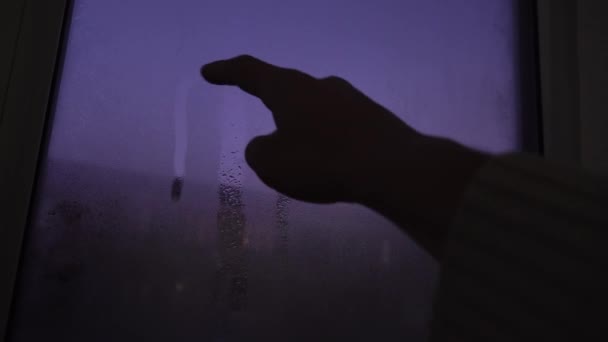 La silhouette della mano di un uomo scrive la parola paura sulla finestra appannata. - Filmati, video