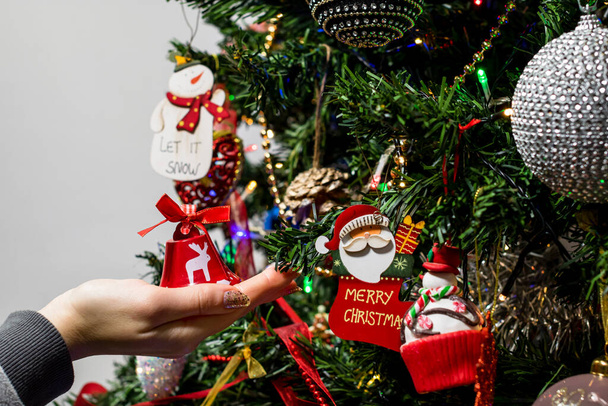 クリスマスツリーにクリスマスの装飾品や装飾品をぶら下げ - 写真・画像