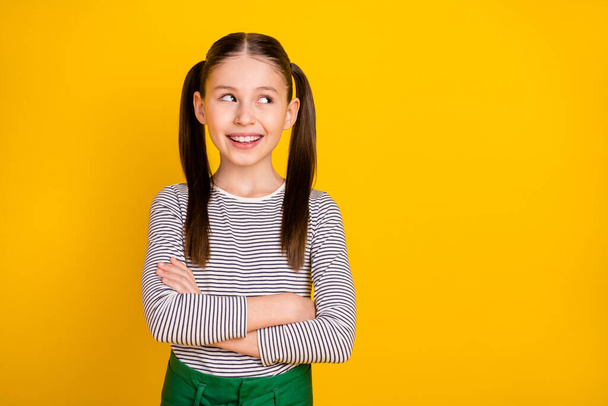 Photo of young cheerful girl happy positive smile folded hands dream look empty space isolated over yellow color background - Foto, afbeelding