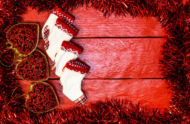 Kerstcompositie op rood houten bord met kerstslinger en decoraties. Creatieve compositie met rand- en kopieerruimte, bovenaanzicht, vlak gelegd. Kerst frame. - Foto, afbeelding