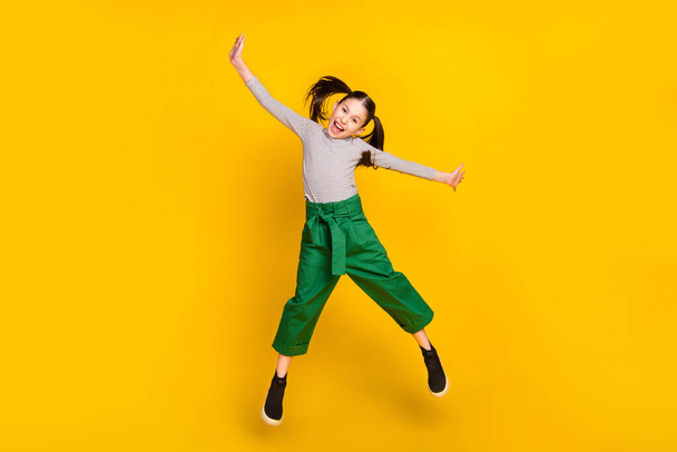 Full size photo of young excited girl happy positive smile have fun jump up isolated over yellow color background - Foto, Imagem