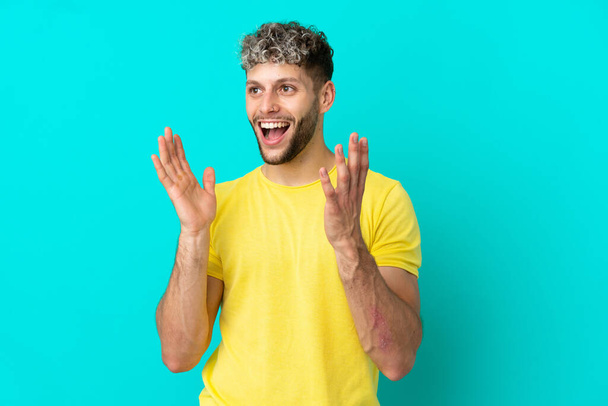 Young handsome caucasian man isolated on blue background with surprise facial expression - Photo, Image
